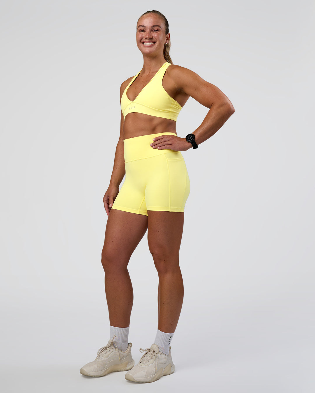 Woman wearing Fusion Ultra High-Rise 4&quot; Short Pockets - Yellow Fizz | Model:Sav | Size:S