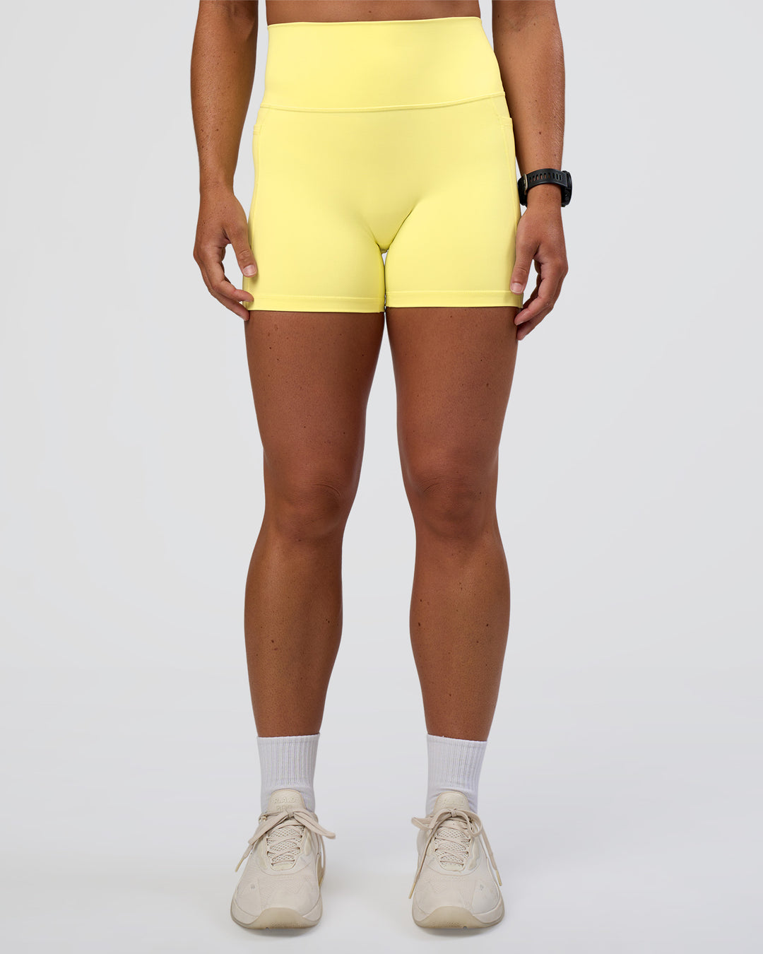 Woman wearing Fusion Ultra High-Rise 4&quot; Short Pockets - Yellow Fizz | Model:Sav | Size:S