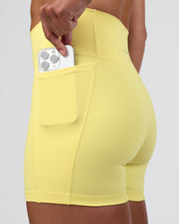 Woman wearing Fusion Ultra High-Rise 4" Short Pockets - Yellow Fizz | Set:true | Angle:closeup | Model:Sav | Size:S