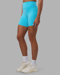 Woman wearing Fusion Ultra High-Rise 6" Short - Blue Atoll | Set:true | Angle:side | Model:Katie | Size:S