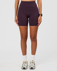 Woman wearing Fusion Ultra High-Rise 6" Short - Midnight Plum | Set:true | Angle:front | Model:Rhiley | Size:S