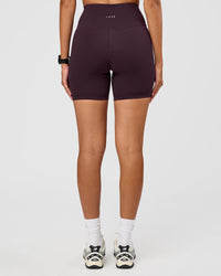 Woman wearing Fusion Ultra High-Rise 6" Short - Midnight Plum | Set:true | Angle:back | Model:Rhiley | Size:S
