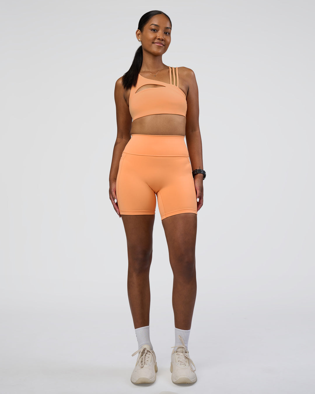 Woman wearing Fusion Ultra High-Rise 6&quot; Short Pockets - Cantaloupe | Model:Rica | Size:S