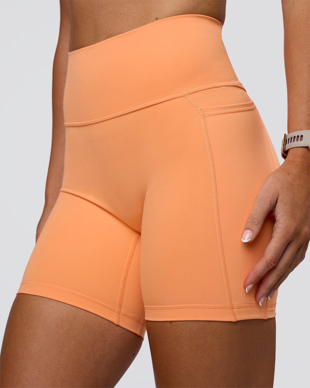 Woman wearing Fusion Ultra High-Rise 6" Short Pockets - Cantaloupe | Model:Emelia | Size:S