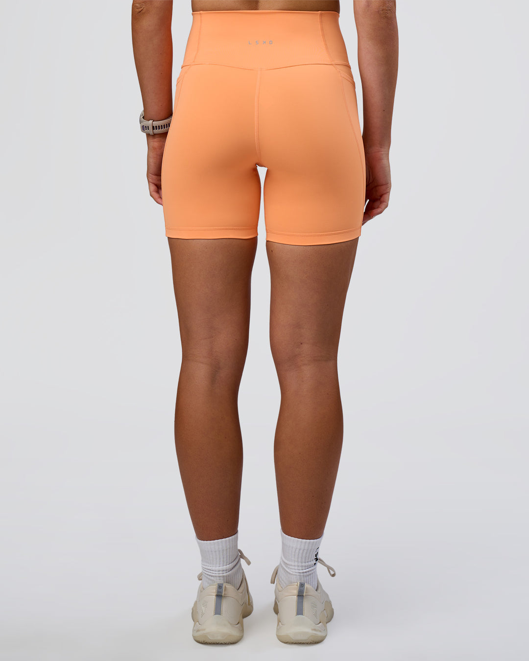 Woman wearing Fusion Ultra High-Rise 6" Short Pockets - Cantaloupe | Model:Emelia | Size:S