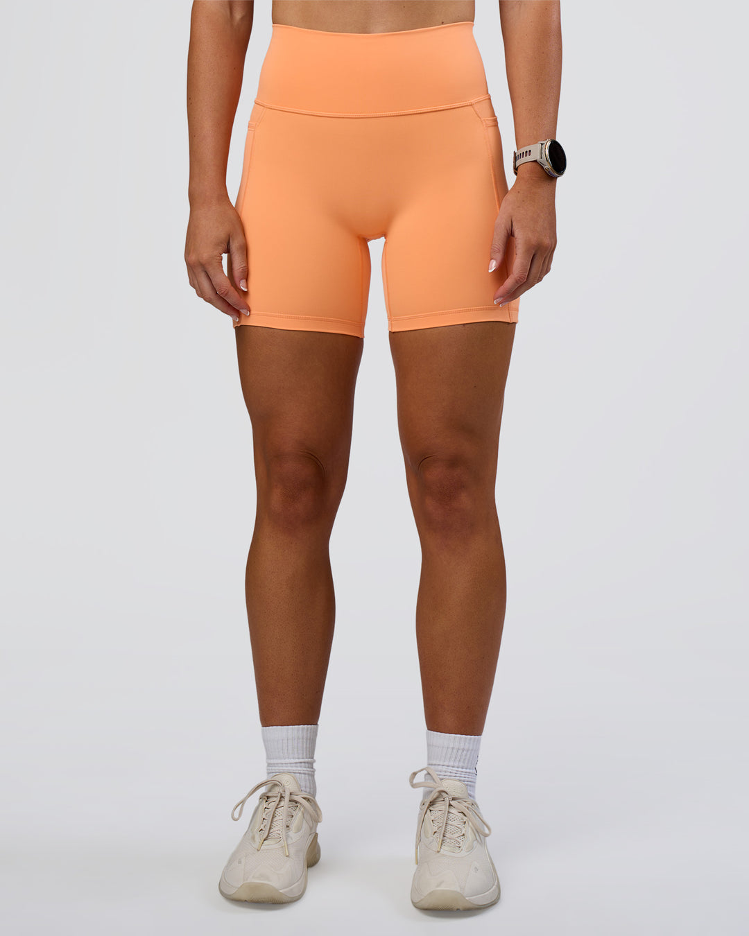 Woman wearing Fusion Ultra High-Rise 6" Short Pockets - Cantaloupe | Model:Emelia | Size:S