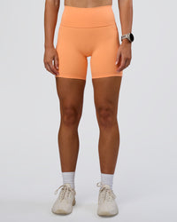 Woman wearing Fusion Ultra High-Rise 6" Short Pockets - Cantaloupe | Set:true | Angle:front | Model:Emelia | Size:S