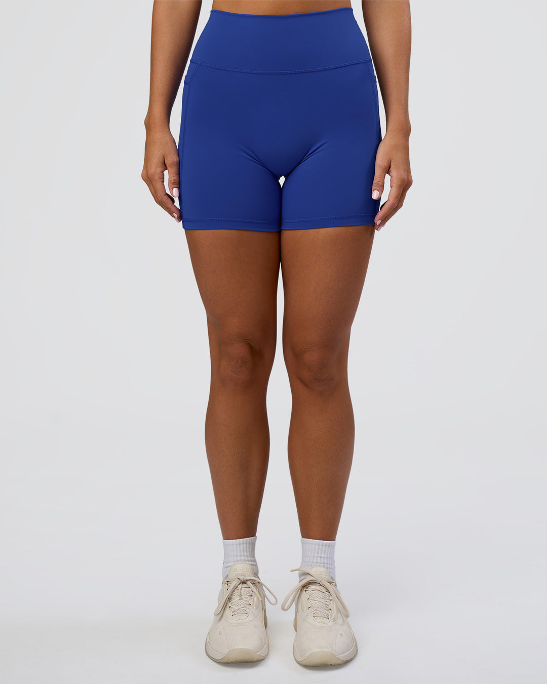 Woman wearing Fusion Ultra High-Rise 6" Short Pockets - Electric Indigo | Set:true | Angle:front | Model:Amity | Size:S