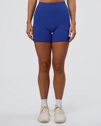 Woman wearing Fusion Ultra High-Rise 6" Short Pockets - Electric Indigo | Set:true | Angle:front | Model:Amity | Size:S