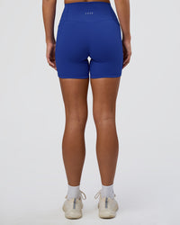 Woman wearing Fusion Ultra High-Rise 6" Short Pockets - Electric Indigo | Set:true | Angle:back | Model:Amity | Size:S