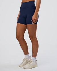 Woman wearing Fusion Ultra High-Rise 6" Short Pockets - Future Navy | Set:true | Angle:side | Model:Amity | Size:S