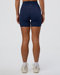 Woman wearing Fusion Ultra High-Rise 6" Short Pockets - Future Navy | Set:true | Angle:back | Model:Amity | Size:S