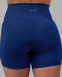 Woman wearing Fusion Ultra High-Rise 6" Short Pockets - Midnight Blue | Model:Charlize | Size:S