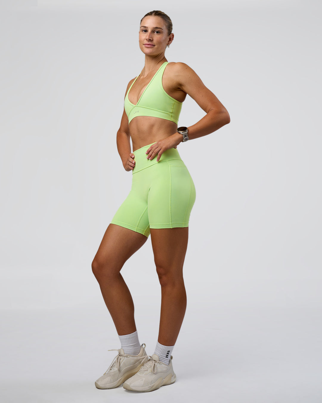 Woman wearing Fusion Ultra High-Rise 6" Short Pockets - Solar Lime | Model:Emelia | Size:S
