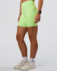 Woman wearing Fusion Ultra High-Rise 6" Short Pockets - Solar Lime | Set:true | Angle:side | Model:Emelia | Size:S