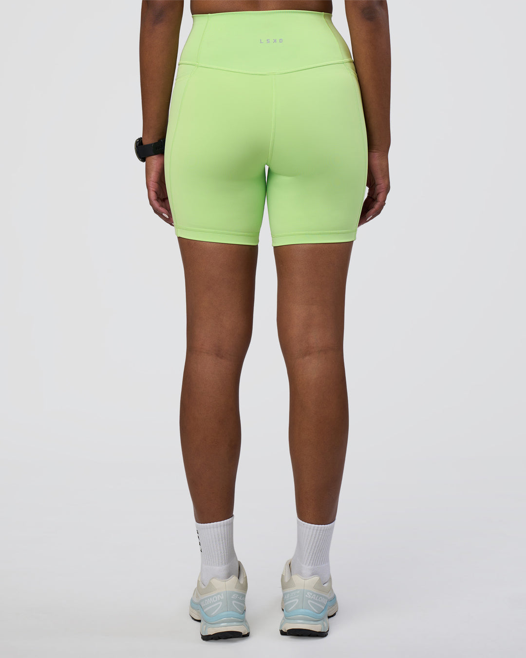 Woman wearing Fusion Ultra High-Rise 6&quot; Short Pockets - Solar Lime | Model:Rica | Size:S