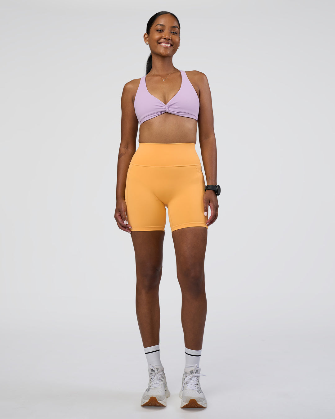 Woman wearing Fusion Ultra High-Rise 6&quot; Short Pockets - Warm Apricot | Model:Rica | Size:S