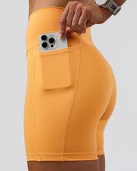 Woman wearing Fusion Ultra High-Rise 6" Short Pockets - Warm Apricot | Set:true | Angle:closeup | Model:Emelia | Size:S