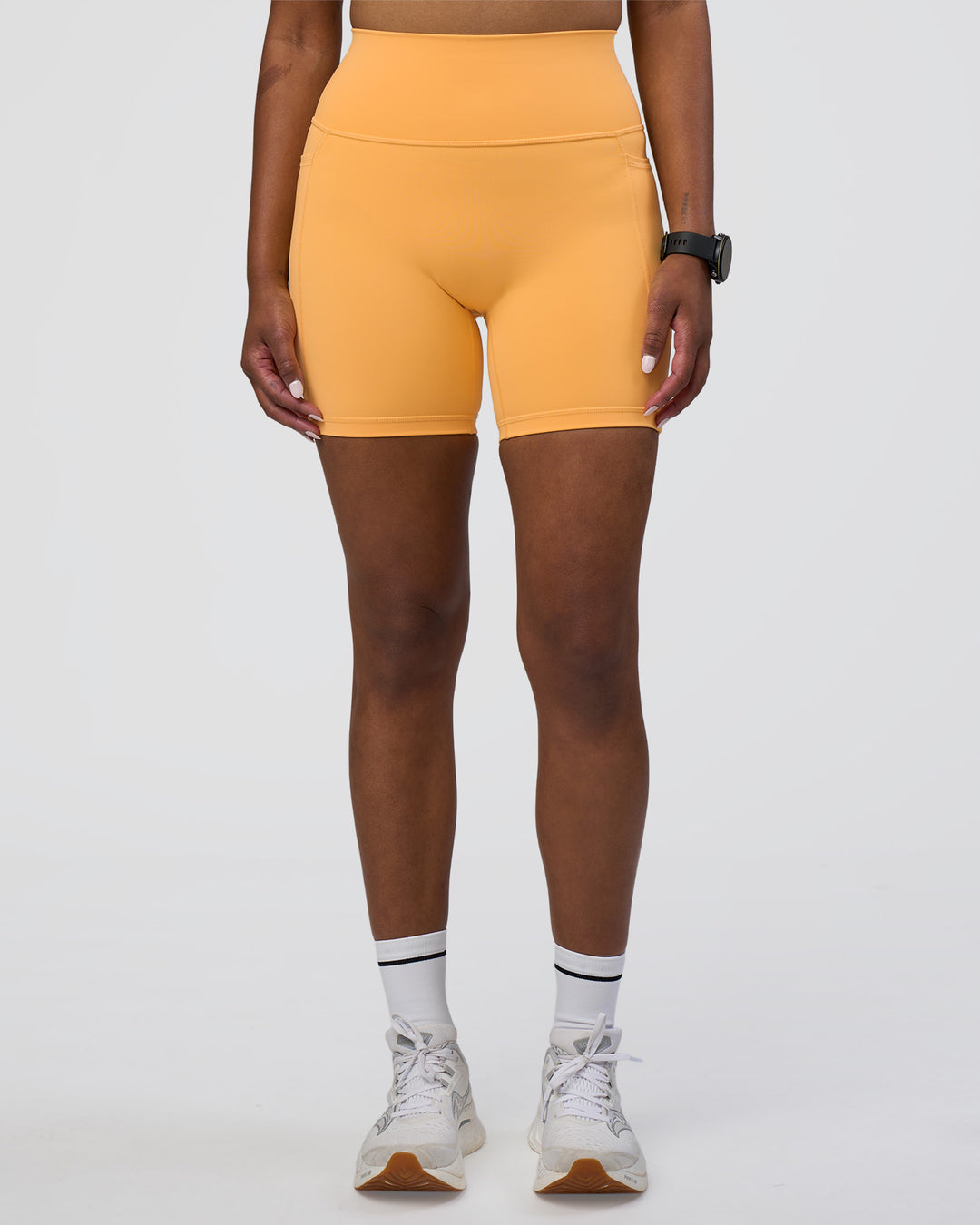 Woman wearing Fusion Ultra High-Rise 6&quot; Short Pockets - Warm Apricot | Model:Rica | Size:S
