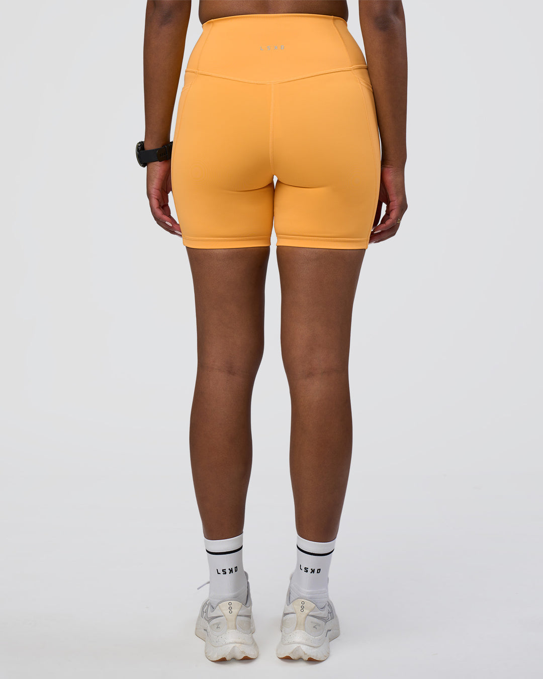 Woman wearing Fusion Ultra High-Rise 6&quot; Short Pockets - Warm Apricot | Model:Rica | Size:S