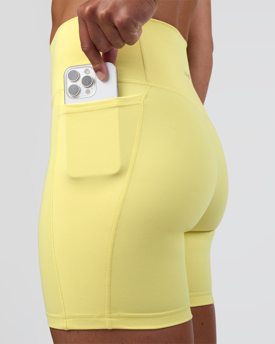 Woman wearing Fusion Ultra High-Rise 6&quot; Short Pockets - Yellow Fizz | Model:Sav | Size:S