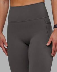 Woman wearing Fusion Ultra High-Rise 7/8 Legging Pockets - Dark Storm | Model:Keisha | Size:S