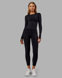 Woman wearing Fusion Ultra High-Rise 7/8 Thermal Legging Pockets - Black | Model:Ella | Size:S