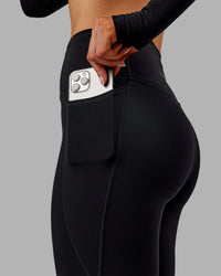 Woman wearing Fusion Ultra High-Rise 7/8 Thermal Legging Pockets - Black | Model:Ella | Size:S