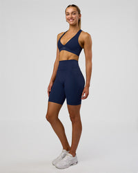 Woman wearing Fusion Ultra High-Rise 9" Short Pockets - Future Navy | Model:Evie | Size:S