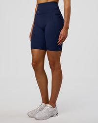 Woman wearing Fusion Ultra High-Rise 9" Short Pockets - Future Navy | Model:Evie | Size:S