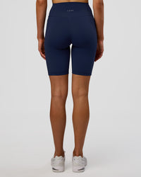Woman wearing Fusion Ultra High-Rise 9" Short Pockets - Future Navy | Model:Evie | Size:S