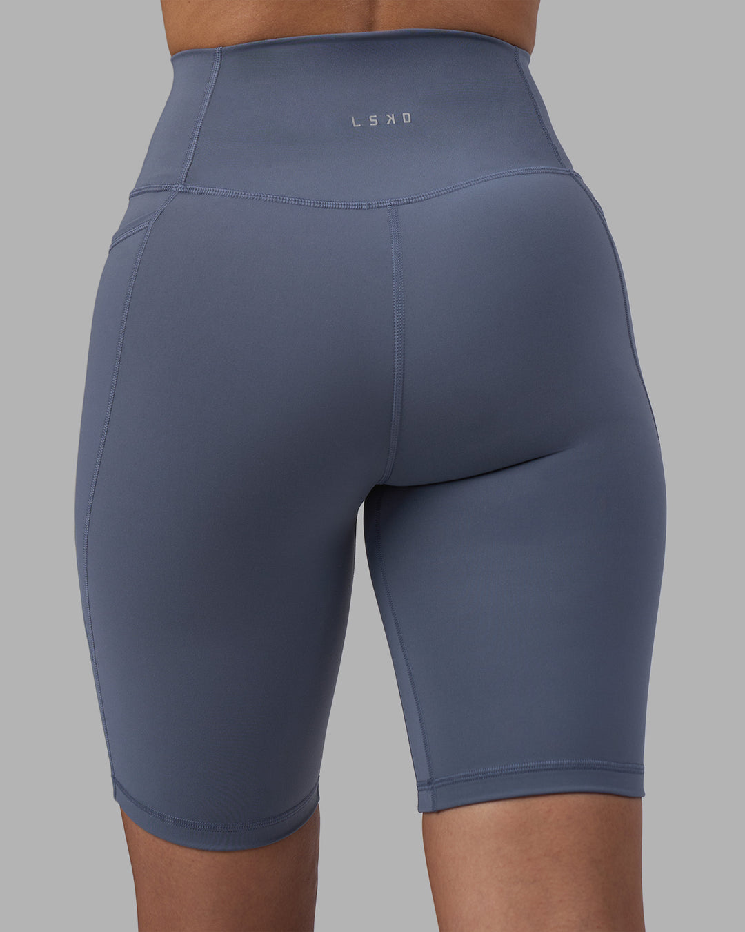Woman wearing Fusion Ultra High-Rise 9&quot; Short Pockets - Night Shadow | Model:Rhiley | Size:S