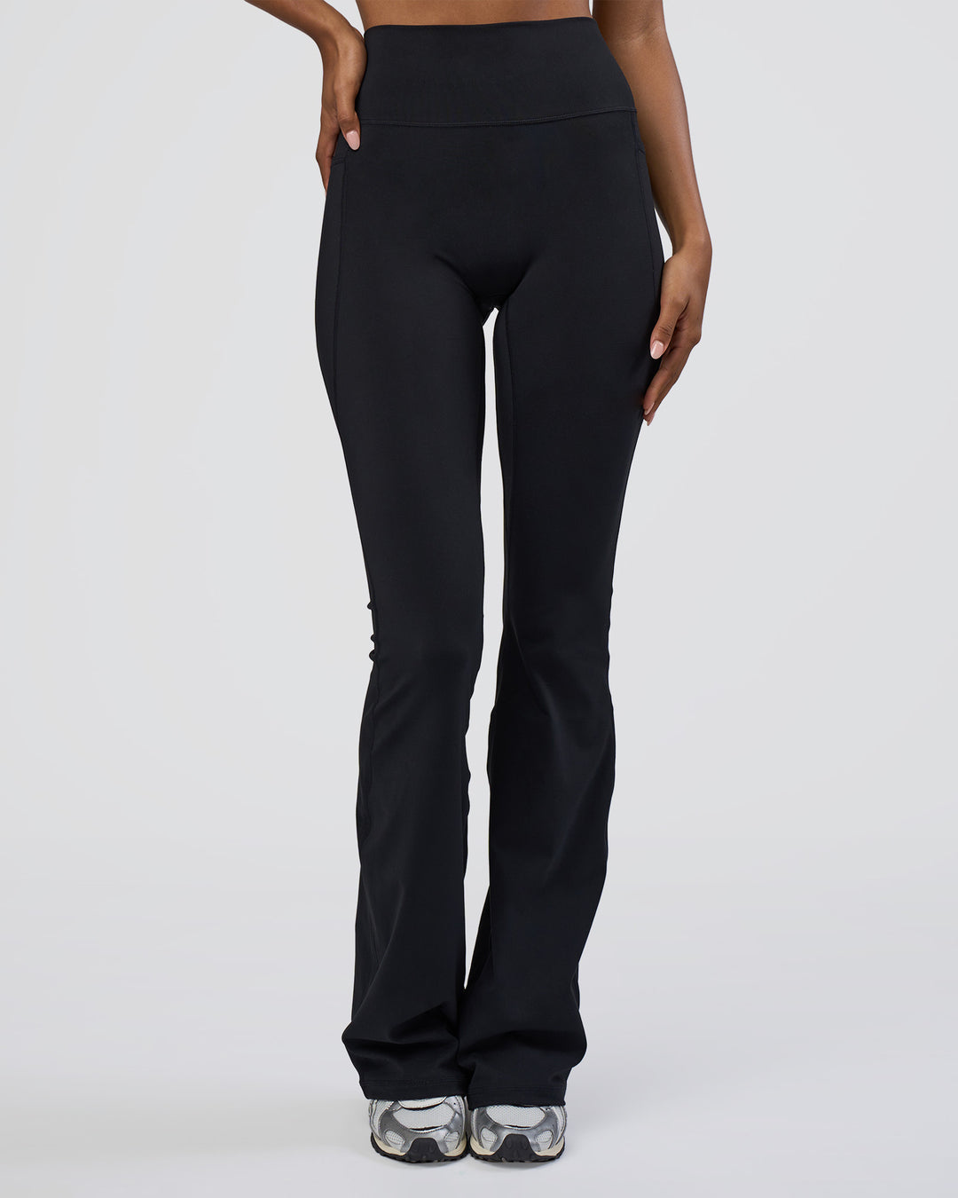 Woman wearing Fusion Ultra High-Rise Flared Tall Legging Pockets - Black | Model:Tomi | Size:S