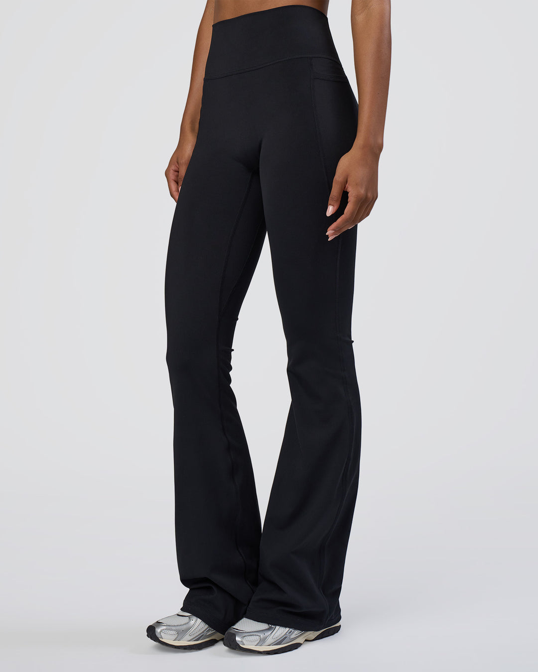 Woman wearing Fusion Ultra High-Rise Flared Tall Legging Pockets - Black | Model:Tomi | Size:S