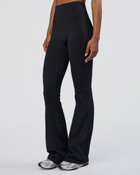 Woman wearing Fusion Ultra High-Rise Flared Tall Legging Pockets - Black | Model:Tomi | Size:S