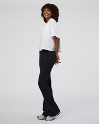 Woman wearing Fusion Ultra High-Rise Flared Tall Legging Pockets - Black | Model:Tomi | Size:S