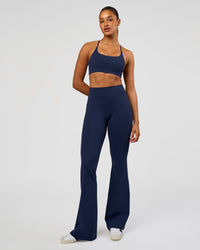 Woman wearing Fusion V-Contour High-Rise Flared Tall Legging Pockets - Future Navy | Model:Rosie | Size:S