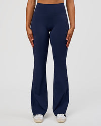 Woman wearing Fusion V-Contour High-Rise Flared Tall Legging Pockets - Future Navy | Model:Rosie | Size:S