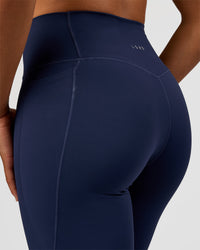 Woman wearing Fusion V-Contour High-Rise Flared Tall Legging Pockets - Future Navy | Model:Rosie | Size:S