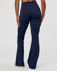 Woman wearing Fusion V-Contour High-Rise Flared Tall Legging Pockets - Future Navy | Model:Rosie | Size:S