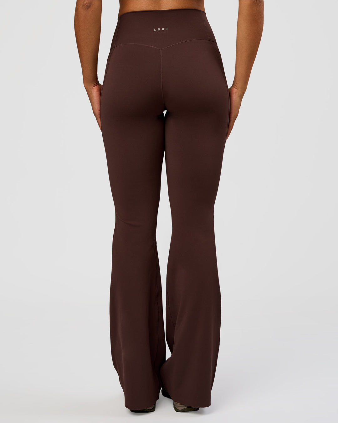 Woman wearing Fusion V-Contour High-Rise Flared Tall Legging Pockets - Hot Chocolate | Model:Rosie | Size:S