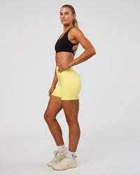 Woman wearing Fusion V-Contour Ultra High-Rise 4” Short Pockets - Yellow Fizz | Model:Emelia | Size:S