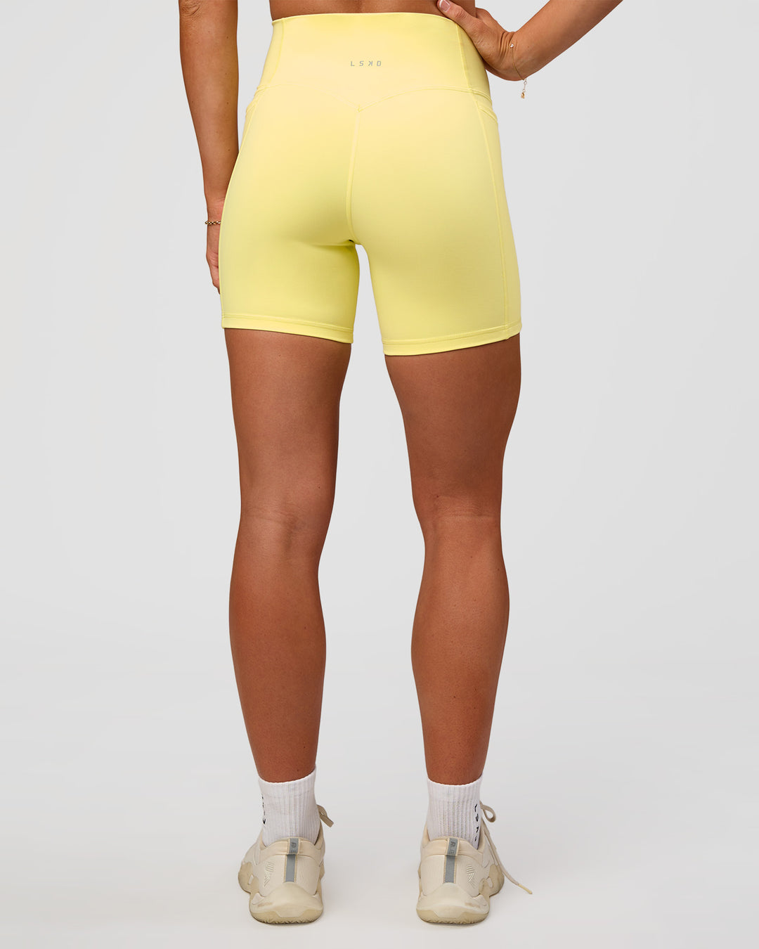 Woman wearing Fusion V-Contour Ultra High-Rise 6" Short Pockets - Yellow Fizz | Model:Emelia | Size:S