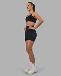 Woman wearing Fusion V-Contour Ultra High-Rise 4” Short Pockets - Black | Model:Charlize | Size:S