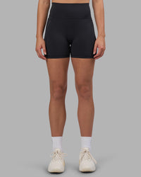 Woman wearing Fusion V-Contour Ultra High-Rise 4” Short Pockets - Black | Model:Charlize | Size:S