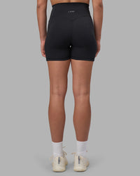 Woman wearing Fusion V-Contour Ultra High-Rise 4” Short Pockets - Black | Model:Charlize | Size:S