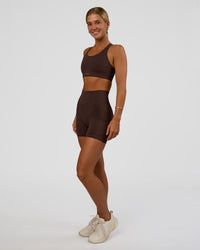 Woman wearing Fusion V-Contour Ultra High-Rise 4” Short Pockets - Hot Chocolate | Model:Amity | Size:S