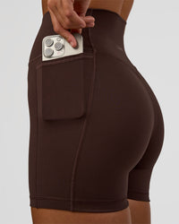 Woman wearing Fusion V-Contour Ultra High-Rise 4” Short Pockets - Hot Chocolate | Model:Amity | Size:S