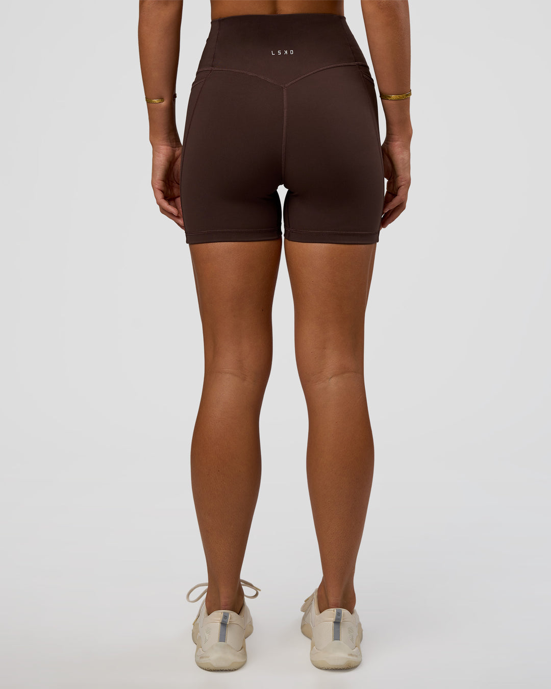 Woman wearing Fusion V-Contour Ultra High-Rise 4” Short Pockets - Hot Chocolate | Model:Amity | Size:S