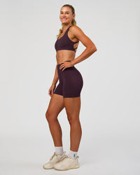 Woman wearing Fusion V-Contour Ultra High-Rise 4” Short Pockets - Midnight Plum | Model:Emelia | Size:S